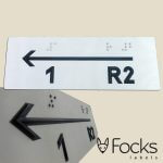 Signage in braille. Arrow, text and QR code laser engraved extra black for the visually impaired